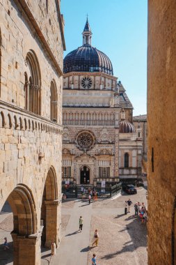 Bergamo, İtalya - 22 Haziran 2025: Günışığı kemerleri, aşağıdaki meydanda toplanan ziyaretçiler, eski Citta Alta duvarlarının gölgeleri arasında hareket ederken Cappella Colleoni 'nin manzarasını çerçevelemektedir.