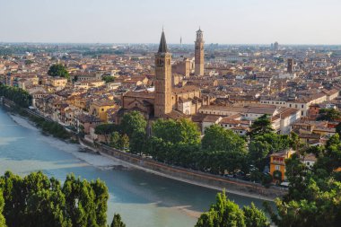 Yüksek bir bakış açısıyla, Verona, Adige Nehri 'nin etrafını sarar ve Basilica di Sant Anastasia' nın çan kulesi yoğun terasotta çatıları arasında açıkça ortaya çıkar.