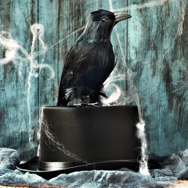 Crow on a top hat in a dismal scene — Stock Photo, Image