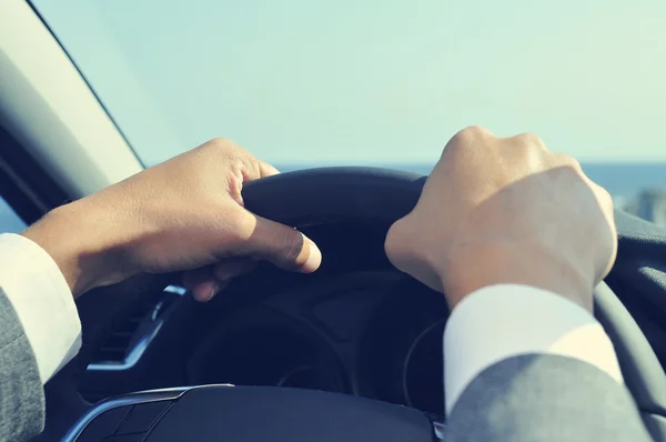 Young man in suit driving a car, filtered — Stock Photo, Image