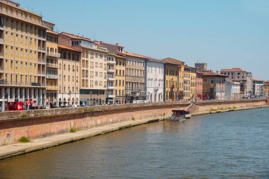 Pisa, İtalya - 26 Haziran 2025: Arno Nehri, San Francesco Mahallesi 'ndeki Lungarno Mediceo' nun renkli cephelerinin yanında nehir kenarındaki yaz ışığı parlayarak Pisa 'dan akar.