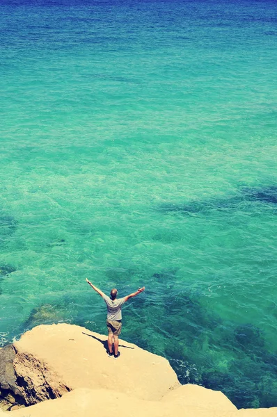 Pria dengan lengan di udara di depan laut, disaring — Stok Foto