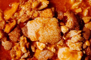 Callos 'un yakın görüntüsü, iyi bilinen bir İspanyol yemeği sığır işkembesi ile hazırlandı ve baharatlı kırmızı bir sosta kaynatıldı, güvecin kırsal malzemelerini ve parlak yüzeyini vurguladı.