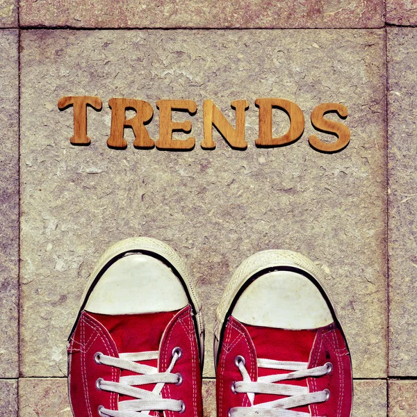 Wooden letters forming the word trends and the feet of a young m — Stock Photo, Image