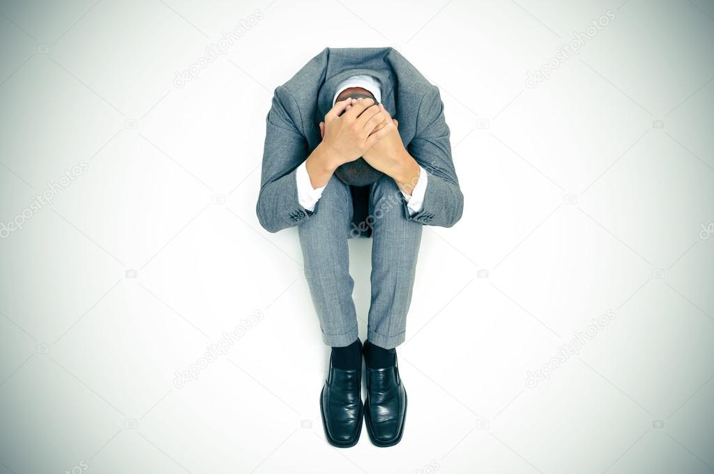 businessman curled up in the floor