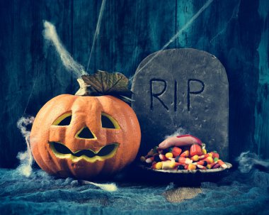 carved pumpkin, gravestone and Halloween candies clipart