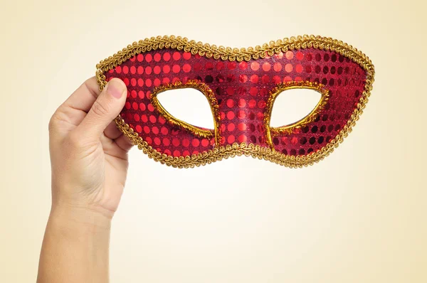 Carnival mask in the hand of a young woman — Stock Photo, Image