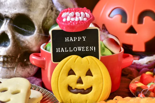 Snoepjes en tekst vrolijke halloween in een schoolbord — Stockfoto