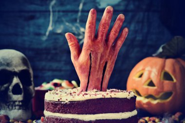 Cadılar Bayramı için korkunç bir sahnede kanlı bir el ile tepesinde kek