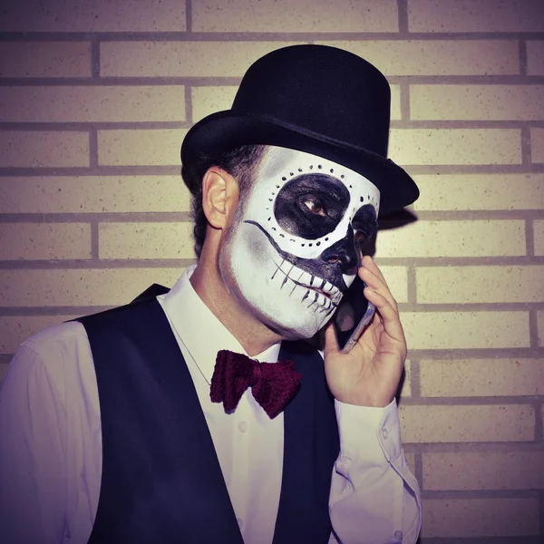 Uomo con calaveras messicano trucco, al telefono — Foto Stock