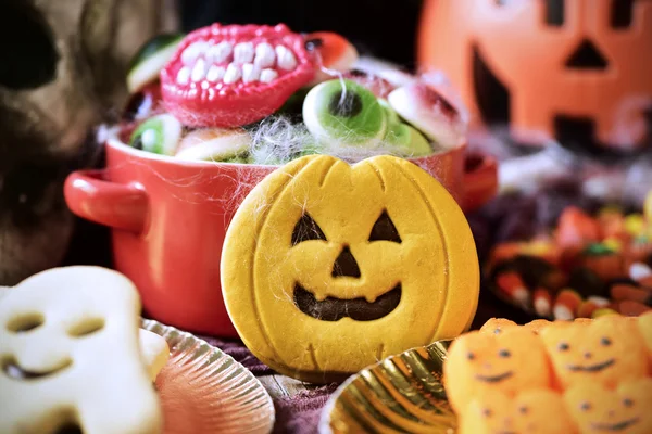 Soubory cookie a bonbóny zdobené tabulce pro Halloween — Stock fotografie