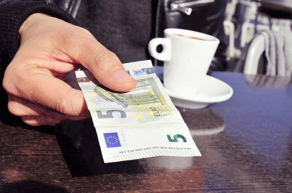 Mann bezahlt die Rechnung auf der Terrasse eines Cafés — Stockfoto
