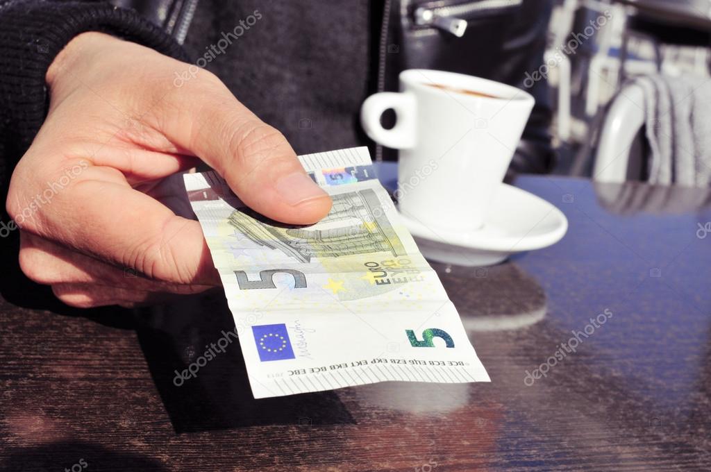man paying the bill in the terrace of a cafe