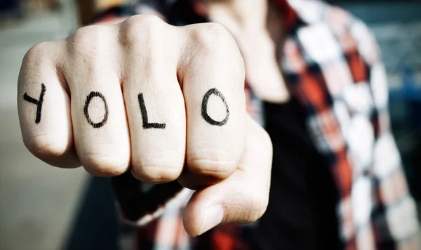 Jeune homme avec le mot yolo dans les doigts — Photo