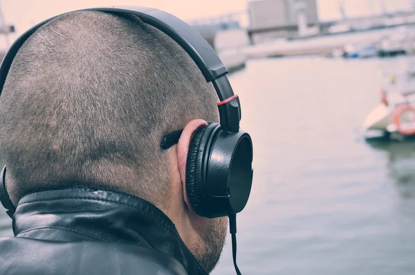 Ung man lyssnar på musik vid havet — Stockfoto