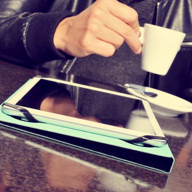 bir fincan kahve ve bir tablet bir Cafe teras ile adam