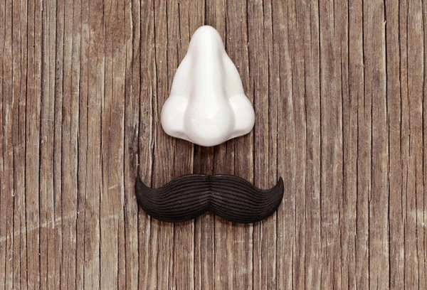 Fałszywe wąsy i nos na powierzchni drewnianych — Zdjęcie stockowe