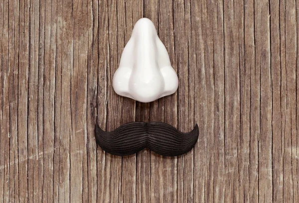 Bigote falso y nariz en una superficie de madera — Foto de Stock