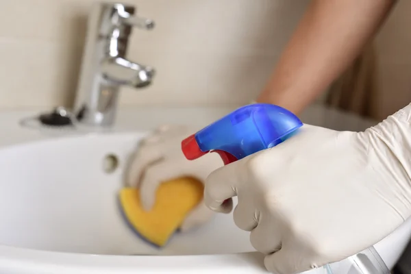 Joven limpieza del lavabo de un cuarto de baño — Foto de Stock