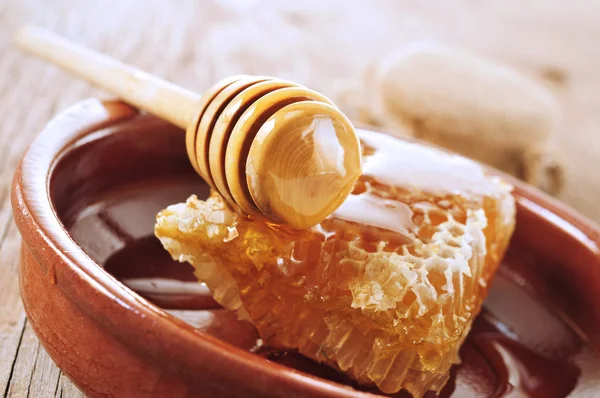 Honungskaka med honung på en trä yta — Stockfoto