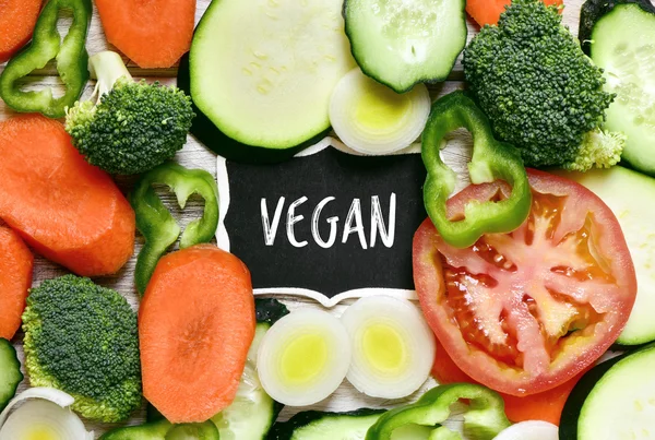 Vegetables and text vegan in a chalkboard — Stock Photo, Image