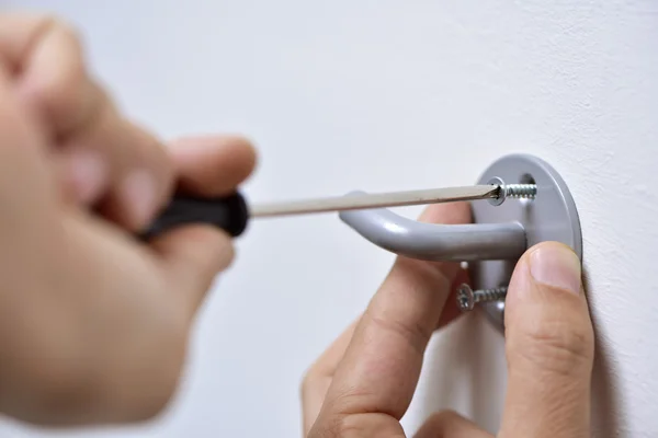 Joven follando un gancho en la pared — Foto de Stock