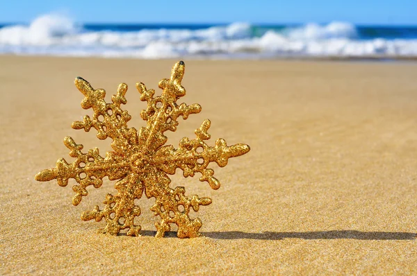 Golden christmas ornament on the beach — Stock Photo, Image
