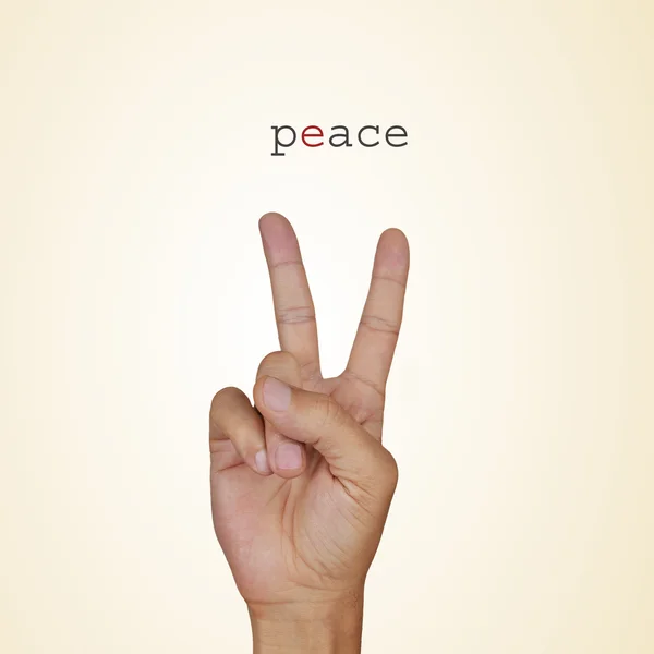Mão do homem dando o sinal V e a palavra paz — Fotografia de Stock