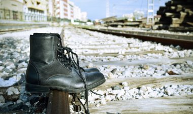 mens boots abandoned on the railroad tracks clipart