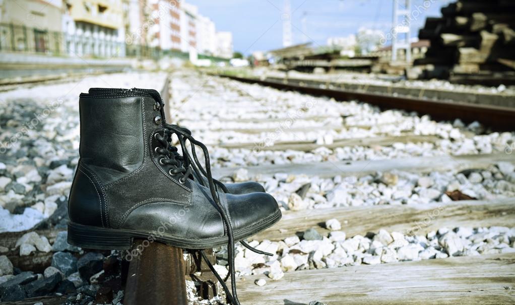 mens boots abandoned on the railroad tracks