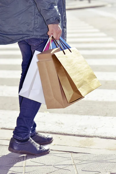 Jovem carregando alguns sacos de compras — Fotografia de Stock