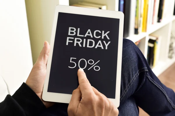 Young man with a tablet with the text black friday — Stock Photo, Image