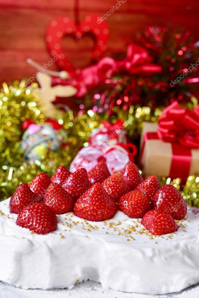 christmas cake covered with cream and topped with strawberries