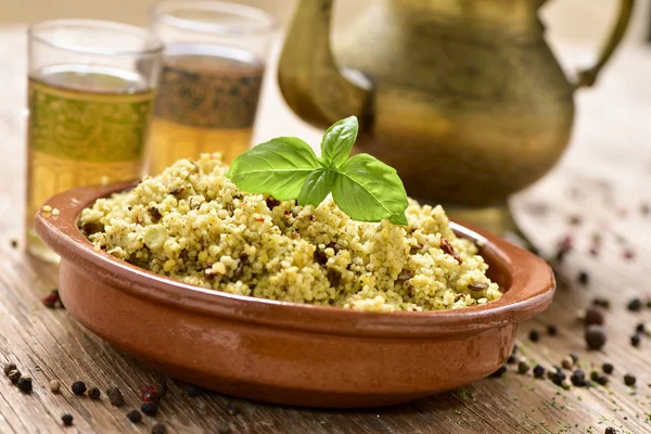 Cuscuz com verduras e chá em uma mesa de madeira rústica — Fotografia de Stock