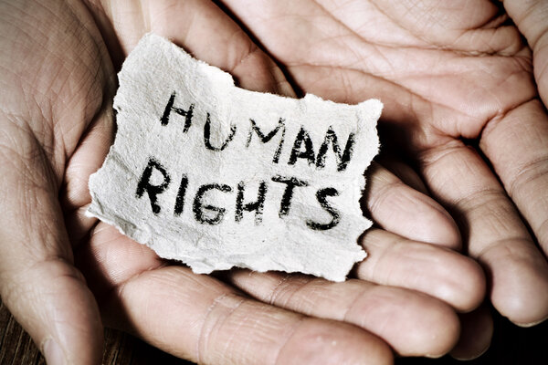молодой человек с бумагой с текстом Human Rights
