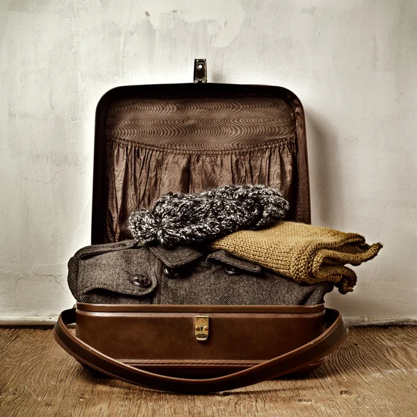 Vecchia valigia con alcuni vestiti caldi — Foto Stock