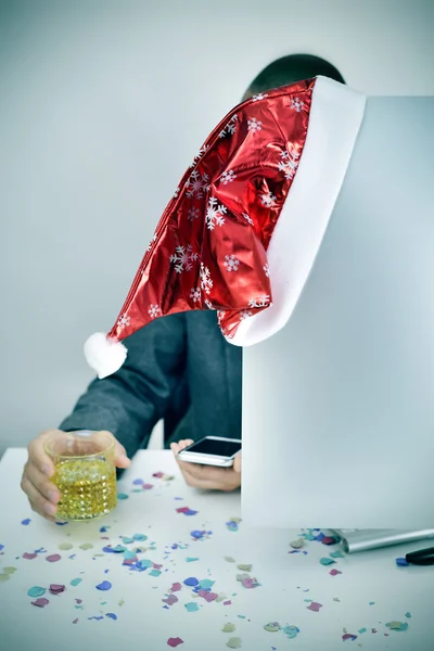 Mann mit einem Glas Schnaps und einem Weihnachtsmann in seinem Büro — Stockfoto