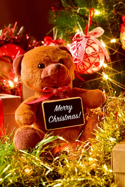 Tekst vrolijk kerstfeest, teddy bear en geschenken — Stockfoto