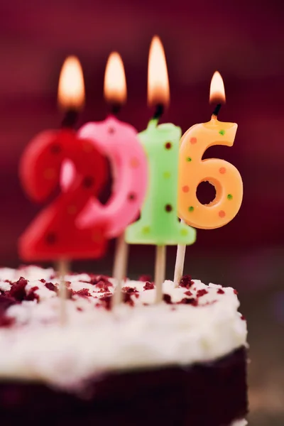 Velas encendidas en forma de número que forman el número 2016 en un pastel —  Fotos de Stock