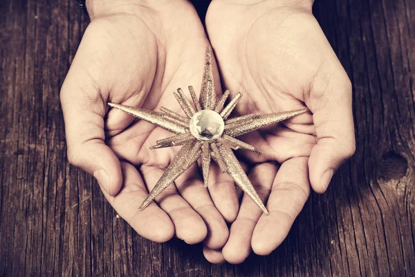 Christmas star in the hands of a man, filtered — Stock Photo, Image