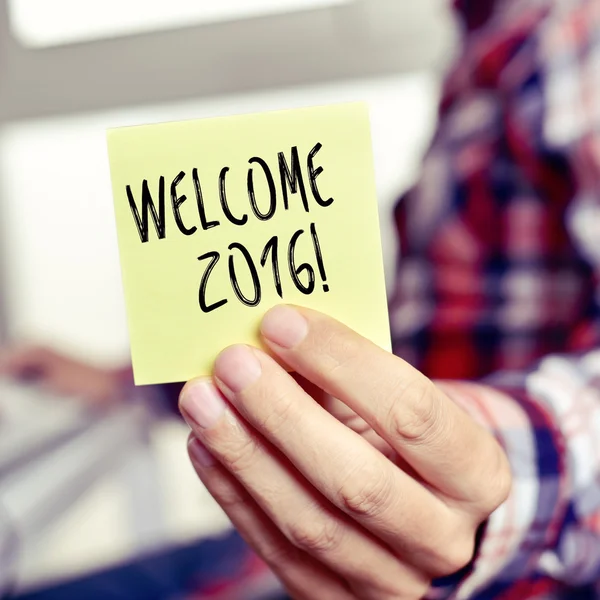 Joven con una nota adhesiva con el texto de bienvenida 2016 — Foto de Stock