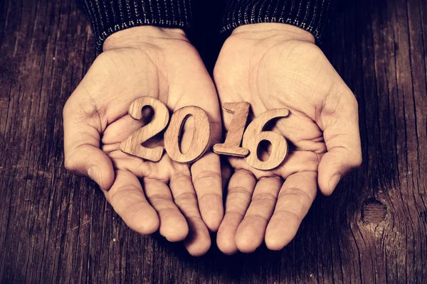 Número 2016, como o ano novo, nas mãos de um homem — Fotografia de Stock