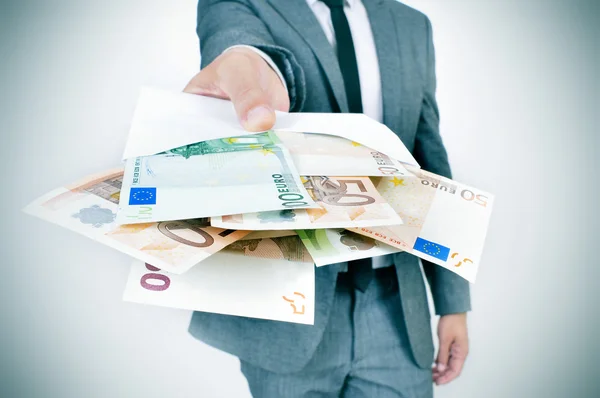 Man giving an envelope full of euro bills — Stock Photo, Image