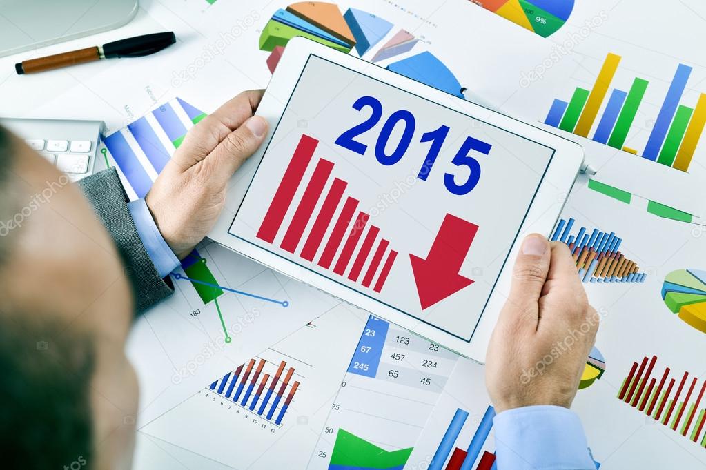 businessman observing a chart with a downward trend during 2015