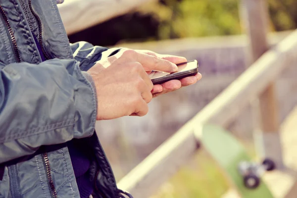 Jonge man met behulp van een smartphone in de buitenlucht — Stockfoto