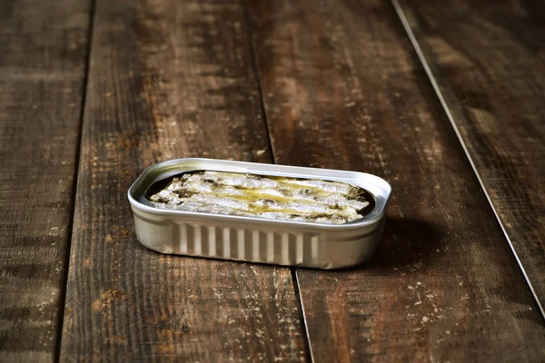 Scatola di sardine su una superficie di legno — Foto Stock