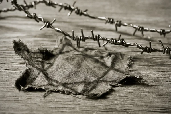 Jewish badge and barbed wire, in sepia toning — Stock Photo, Image