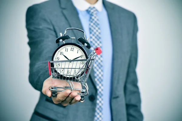 Businessman with an alarm clock in a shopping cart — Stock Photo, Image