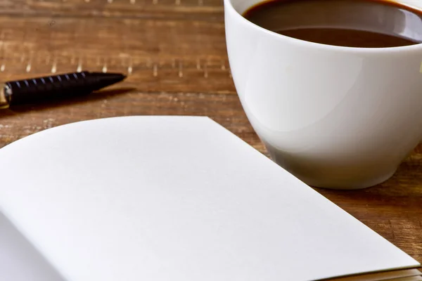 Caderno em branco, caneta e xícara de café — Fotografia de Stock