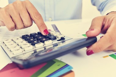 Onun ofisinde bir elektronik hesap makinesi kullanarak iş kadını